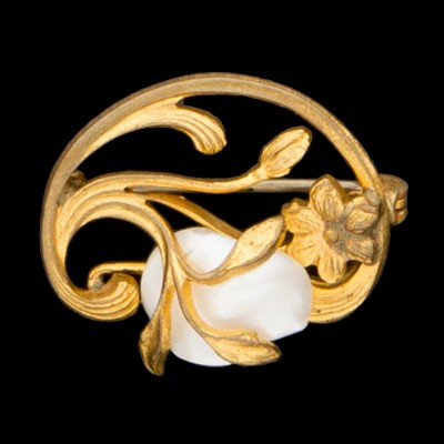Ażurowa broszka z secesyjnym motywem, zdobiona masą perłową. Metal złocony.